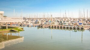 A marina with numerous boats docked, a bridge in the foreground, and calm water reflecting the boats. - Cozy apartment in Torrevieja with house sea view (Torrevieja)