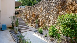 Un mur de pierre avec un escalier menant à un bâtiment.