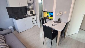 A compact living space with a kitchenette, a dining area, and a sofa.