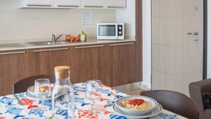 Une cuisine moderne avec des meubles blancs, un four à micro-ondes et un évier.