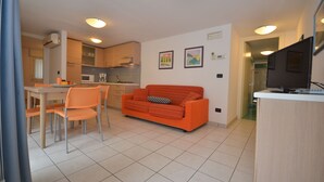A modern apartment with a dining area, kitchen, and living room.
