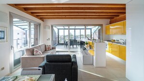 A modern apartment with a living area, kitchen, and balcony.