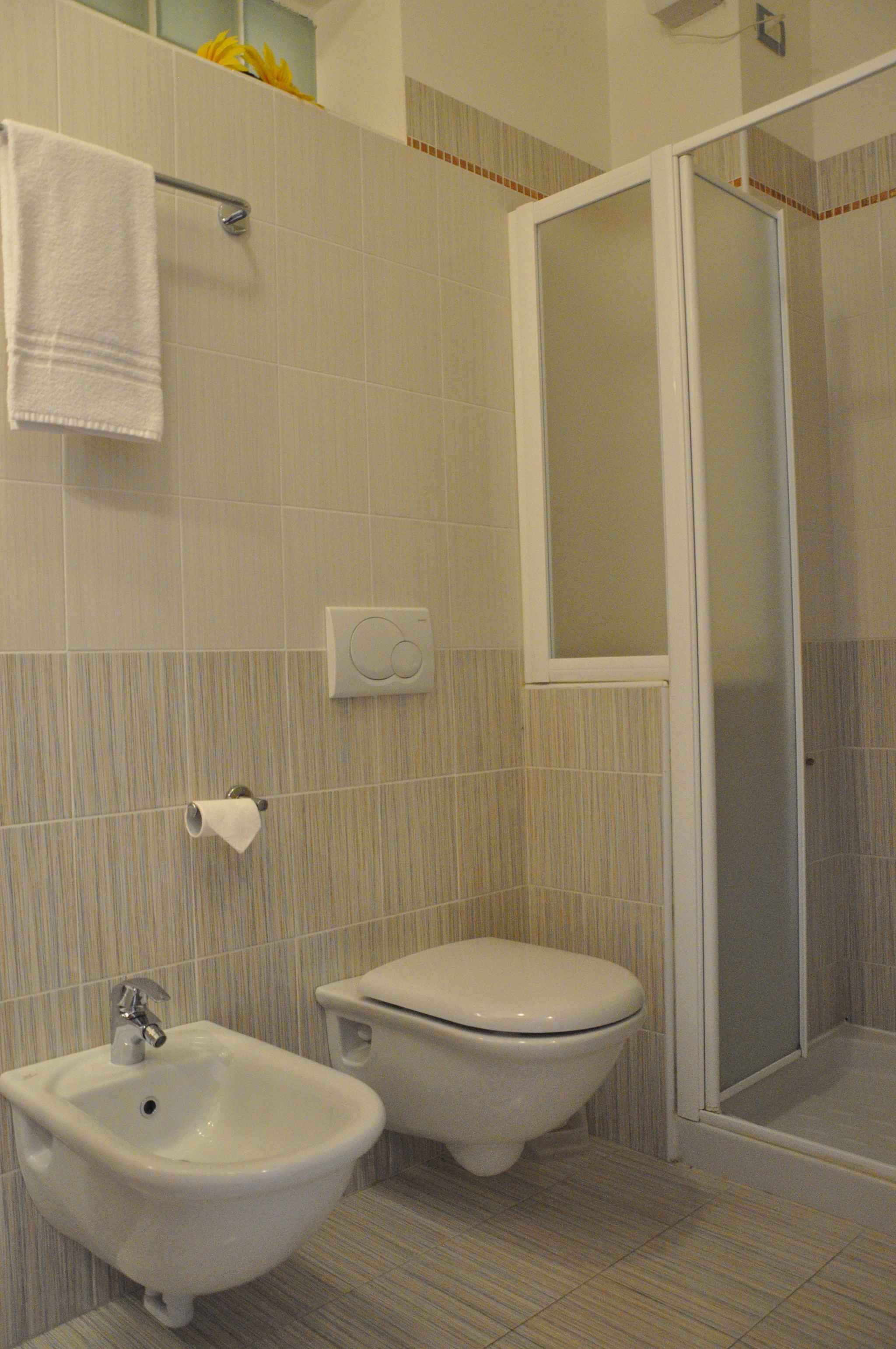 Un baño con bidé, inodoro y cabina de ducha.