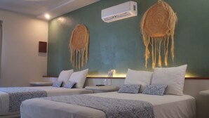 A hotel room with two beds, a wall-mounted air conditioner, and a decorative wall hanging. - Hotel Circulo Bacalar (Bacalar)