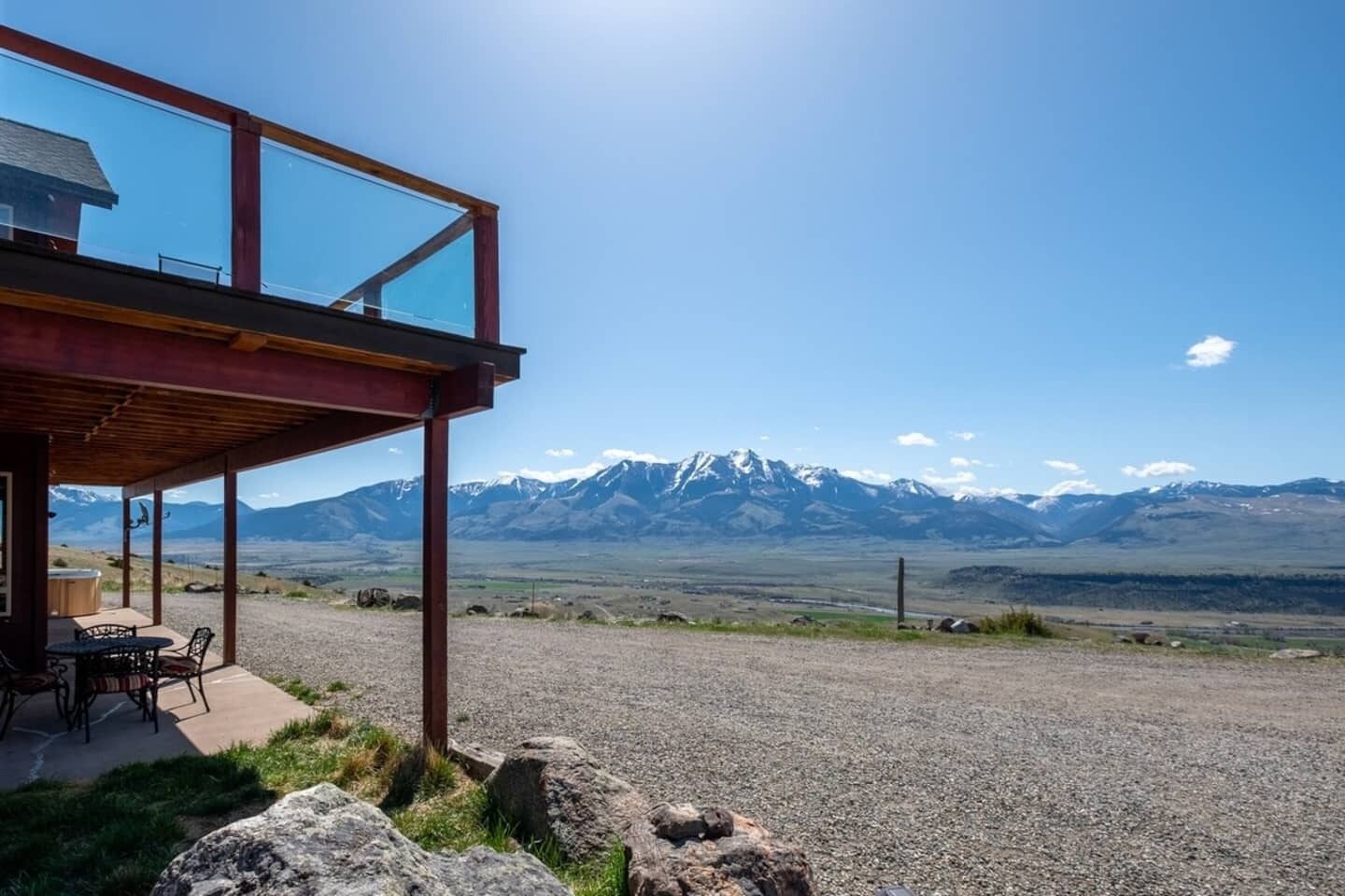 A modern building with a covered patio overlooking a mountainous landscape.