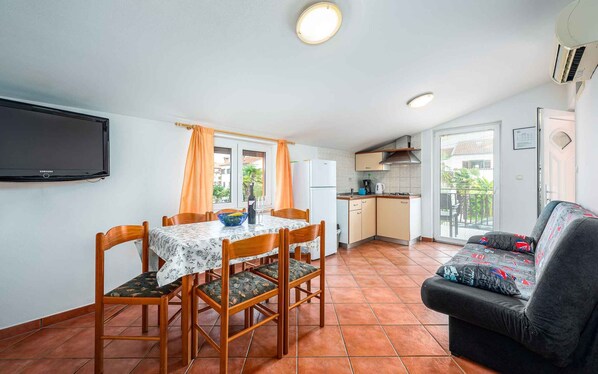 Un espace de vie compact comprenant un coin repas, une kitchenette et un canapé.