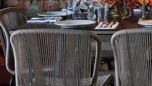 A dining table set with plates, glasses, and a centerpiece with flowers and candles.