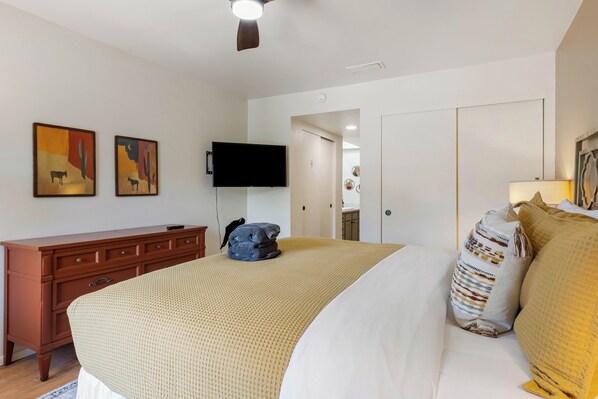 A hotel room with a bed, a dresser, a television, and artwork on the wall. - Sedona Casa Oak Creek: Spacious Remodeled 3BR condo in the heart of Village of Oak Creek. (Sedona)