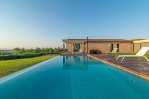 A modern house with a swimming pool, outdoor seating, and a view of the countryside. - SA GARRIGA DEN GARAU - Modern villa with wonderful views and private pool. Free WIFI. (Ariany)