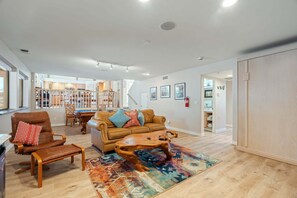 A spacious living area with a brown leather sofa, a wooden coffee table, and a patterned rug.