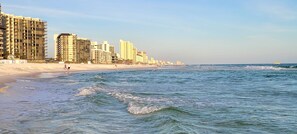 A beach with high-rise buildings in the background. - Beachfront Condo at Grand Panama Beach Resort (Panama City Beach)