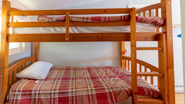 A bunk bed with a plaid bedspread and a white pillow.