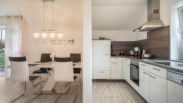 Ett modernt kök med vita skåp, en fläktkåpa i rostfritt stål och en matplats med bord och stolar.