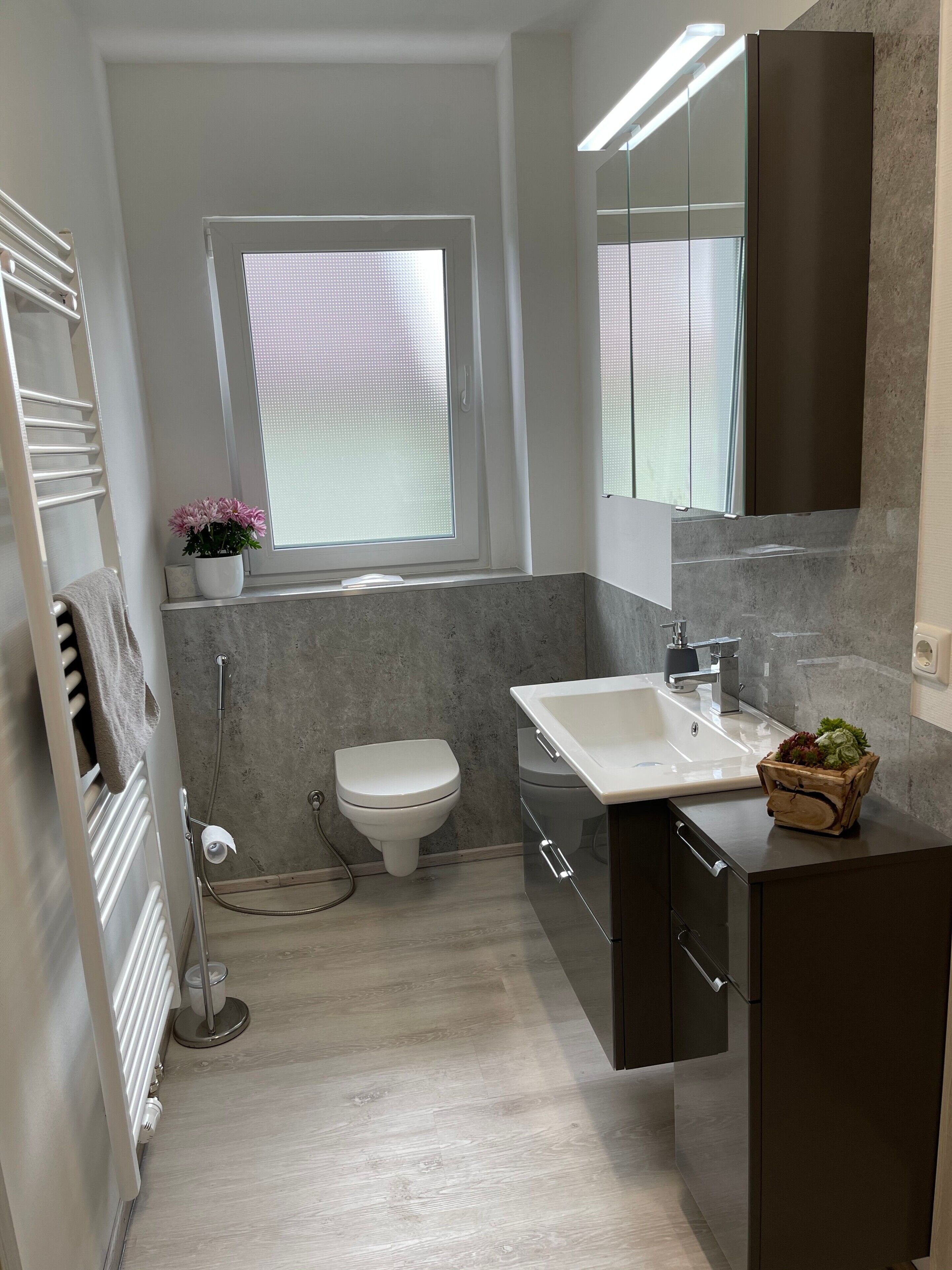 A modern bathroom with a toilet, sink, and shower.