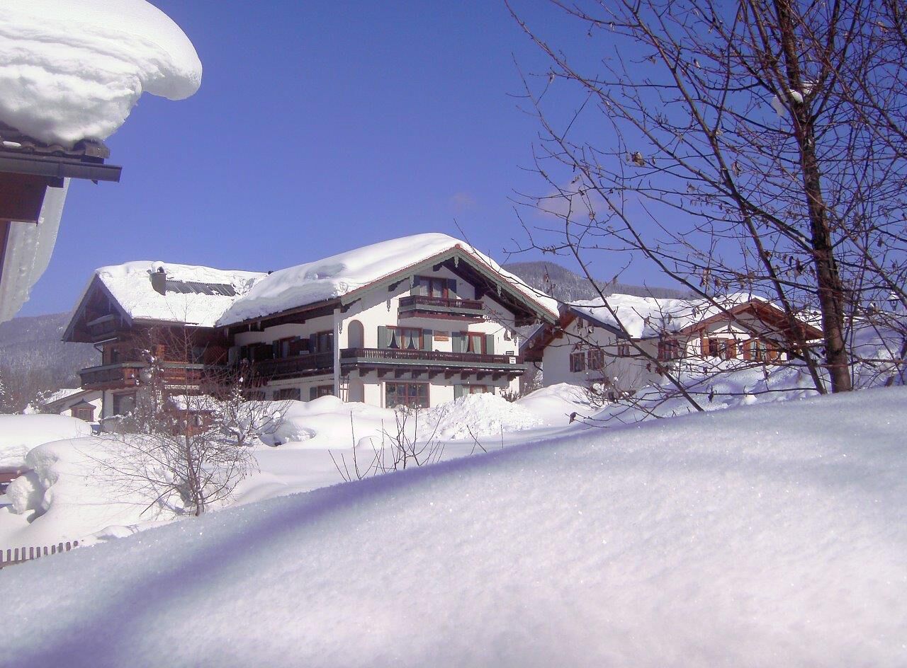A snow-covered lodge with multiple balconies and a prominent roof.