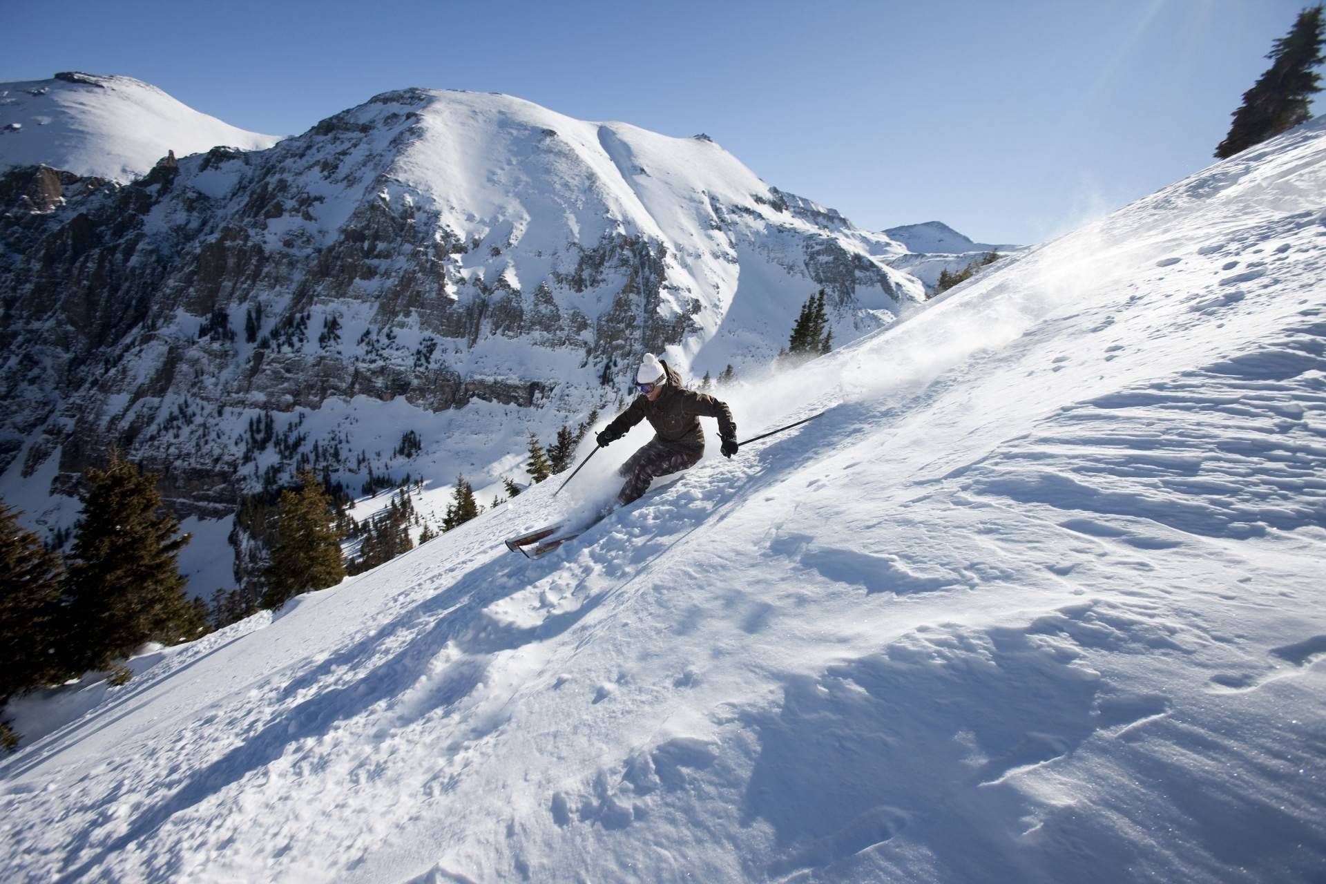 A snowy mountain slope with a skier.