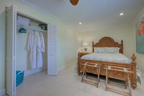A bedroom with a wooden bed, a wardrobe, and a bathroom area. - Lulu's Key House | Sleeps 20 | Walk to Beach (Siesta Key)