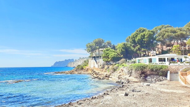 A coastal hotel with a rocky shoreline, clear blue sea, and lush greenery. - Villa Haleakala by Solidays - Moraira, Costa Blanca (Moraira)