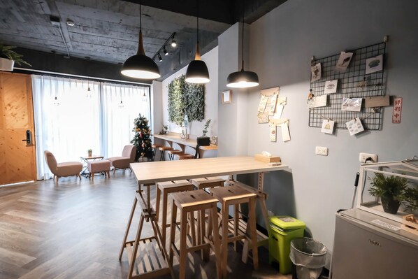 A modern interior with a wooden bar area, seating, and a wall decorated with pictures and plants. - Luke 27 (Tainan)