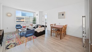 A modern living space with a dining area, a sofa, and a coffee table.