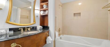 A modern bathroom with a large mirror, a vanity with a sink, and a separate shower area.