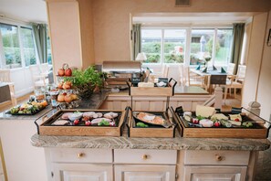 A kitchen with a buffet setup, including various food items and a grill.
