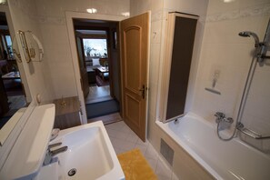 A bathroom with a bathtub, a shower, and a sink. - Vacation apartment 2 - Haus Bergland (Ried)