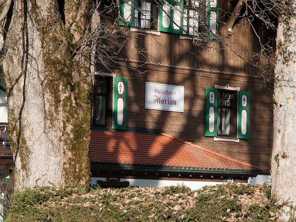 A traditional building with a sign reading 'Gästehaus Florian' and green window shutters.