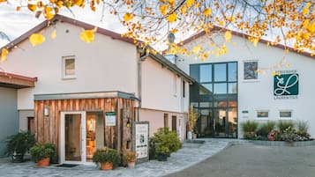A building with a wooden facade, a glass entrance, and signage for 'FERRIENFÖHR LAURENTIUS.'