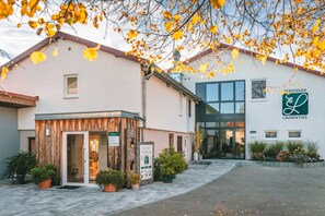 Un edificio con fachada de madera, entrada de vidrio y señalización que dice 'FERRIENFÖHR LAURENTIUS'.