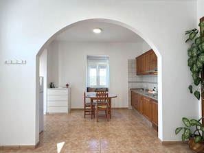 Cozinha com mesa de jantar, cadeiras e janela.