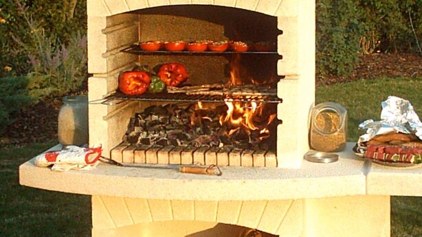 Un horno de ladrillo al aire libre con comida cocinándose en su interior.