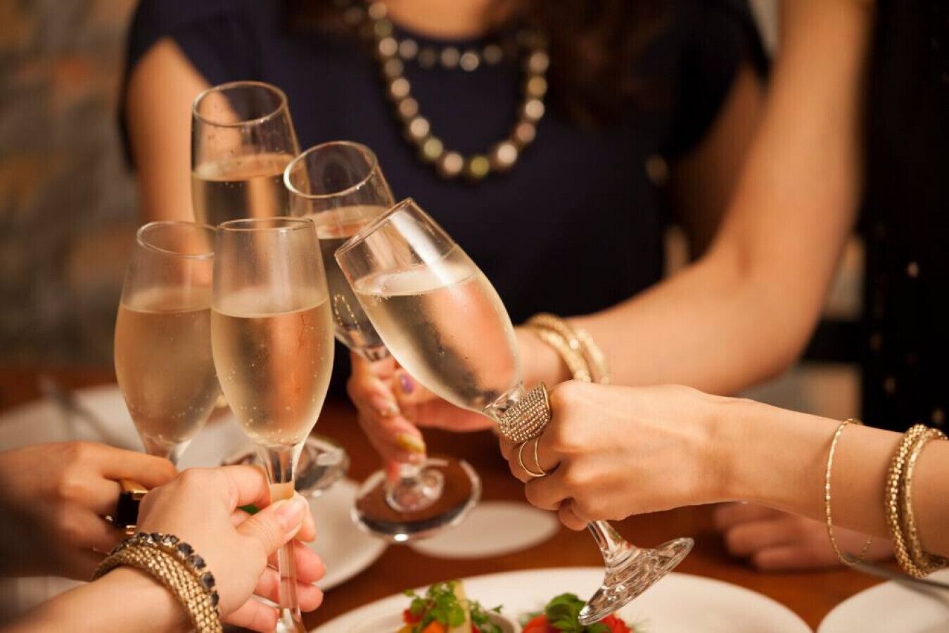 A group of people toasting with champagne glasses at a table.