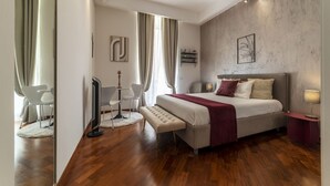Un dormitorio moderno con una cama grande, mesitas de noche, un escritorio y una silla.