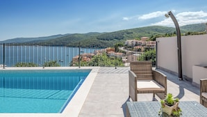 A swimming pool with a view of a coastal town and mountains. - Stunning home in Rabac (Rabac)