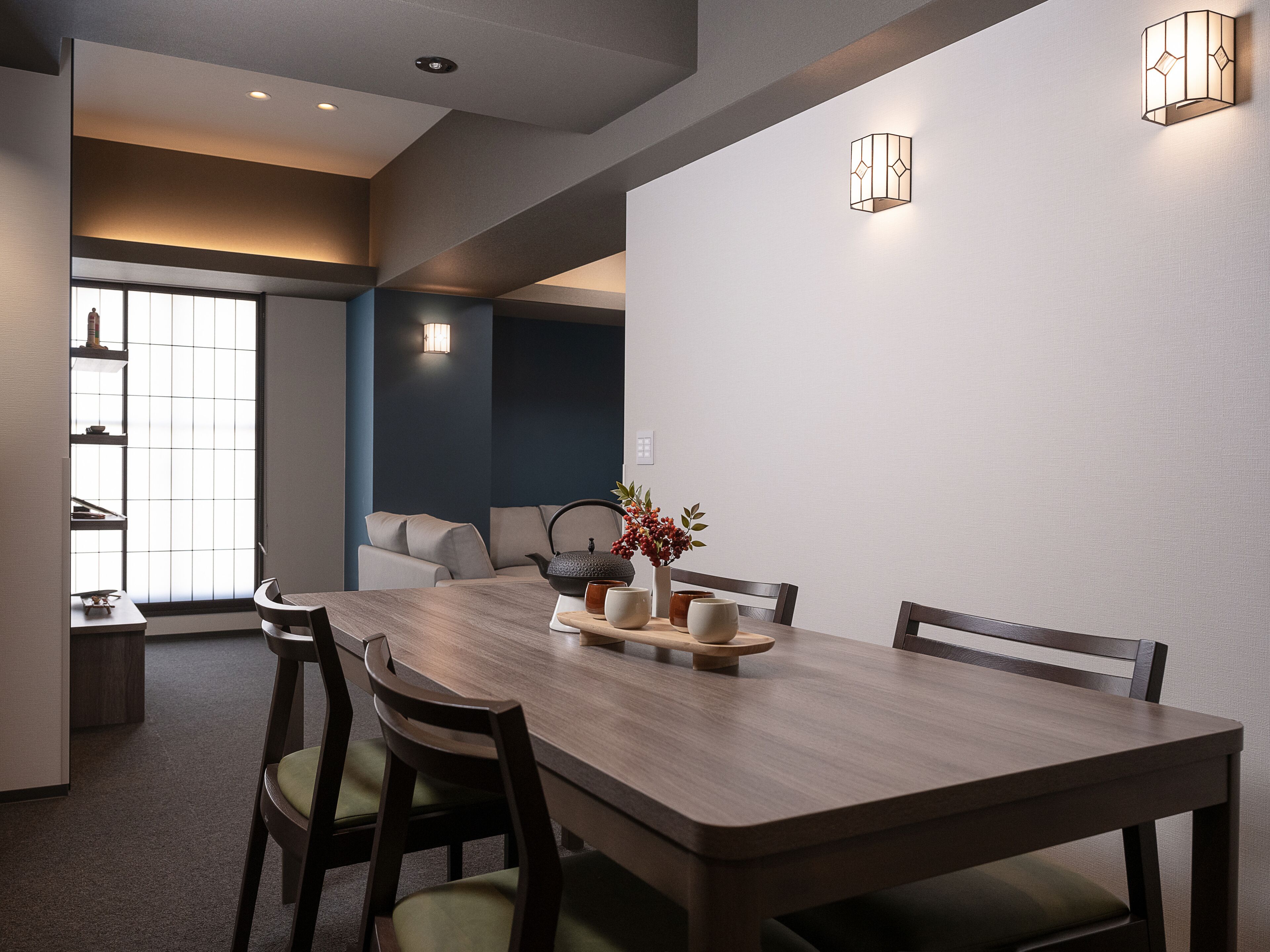 A modern dining area with a wooden table, chairs, and a vase with flowers.