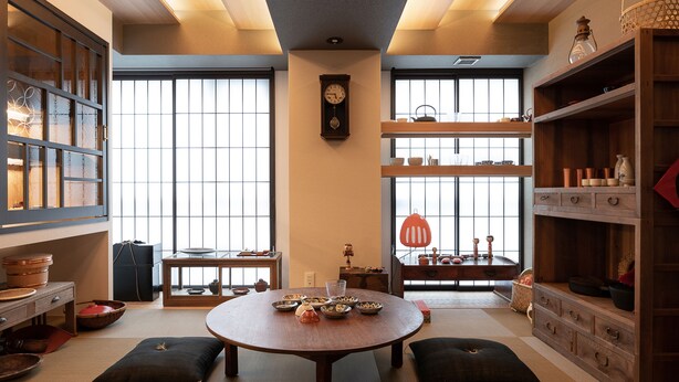 A traditional Japanese-style room with tatami flooring, a low table with cushions, and a view through large windows. - MIMARU SUITES Kyoto Central (Kyoto)