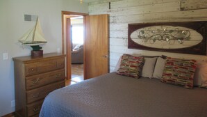 Un dormitorio con cama, cómoda y decoración náutica.