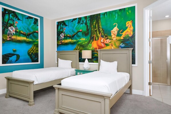 A hotel room with two beds, a large jungle-themed mural, a small table with a lamp, and a shower area.