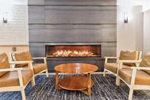 A modern interior with a fireplace, two leather sofas, and a round wooden table. - Ski In - Ski Out. Perfect Location. Hot Tub. Pool. (Breckenridge)