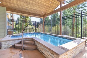 A swimming pool with a wooden deck, stone steps, and a metal fence. - Ski In - Ski Out. Perfect Location. Hot Tub. Pool. (Breckenridge)