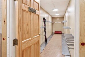 A hotel corridor with wooden doors, a ski locker, and metal drying racks. - Ski In - Ski Out. Perfect Location. Hot Tub. Pool. (Breckenridge)
