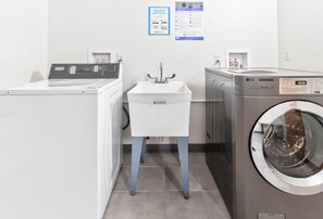 A laundry facility with a washing machine, dryer, and a sink.