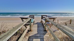 A wooden boardwalk leading to beach seating with a view of the ocean. - Wave To Cool: 4-bedroom oceanfront cottage in Surf City, NC. (Surf City)