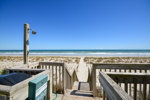 A wooden boardwalk leading to a beach with a clear sky. - Oceanfront 2BR Condo at Queen's Grant C-109 (Topsail Beach)