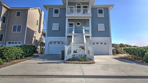 A multi-story residential building with a central staircase, a front porch, and a sign that reads "C. BREEZE". - C-Breeze: Oceanfront 4BR home in Surf City, NC, sleeps 13 comfortably. (Surf City)