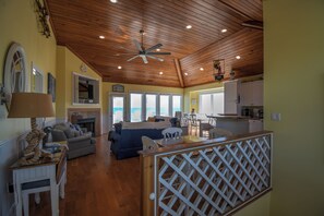 A spacious living area with a fireplace, a dining table, and a kitchen area with white cabinets.