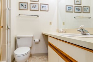 Une salle de bain avec des toilettes, un lavabo et des tableaux encadrés accrochés au mur.