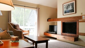 Una sala de estar acogedora con chimenea, televisor y un espacio de descanso cómodo.