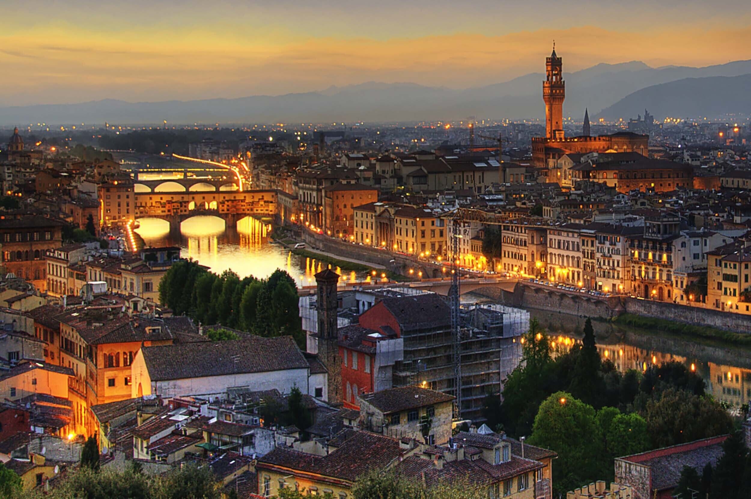 Un paysage urbain caractérisé par une architecture historique, une tour imposante et un pont dont les structures sont illuminées.